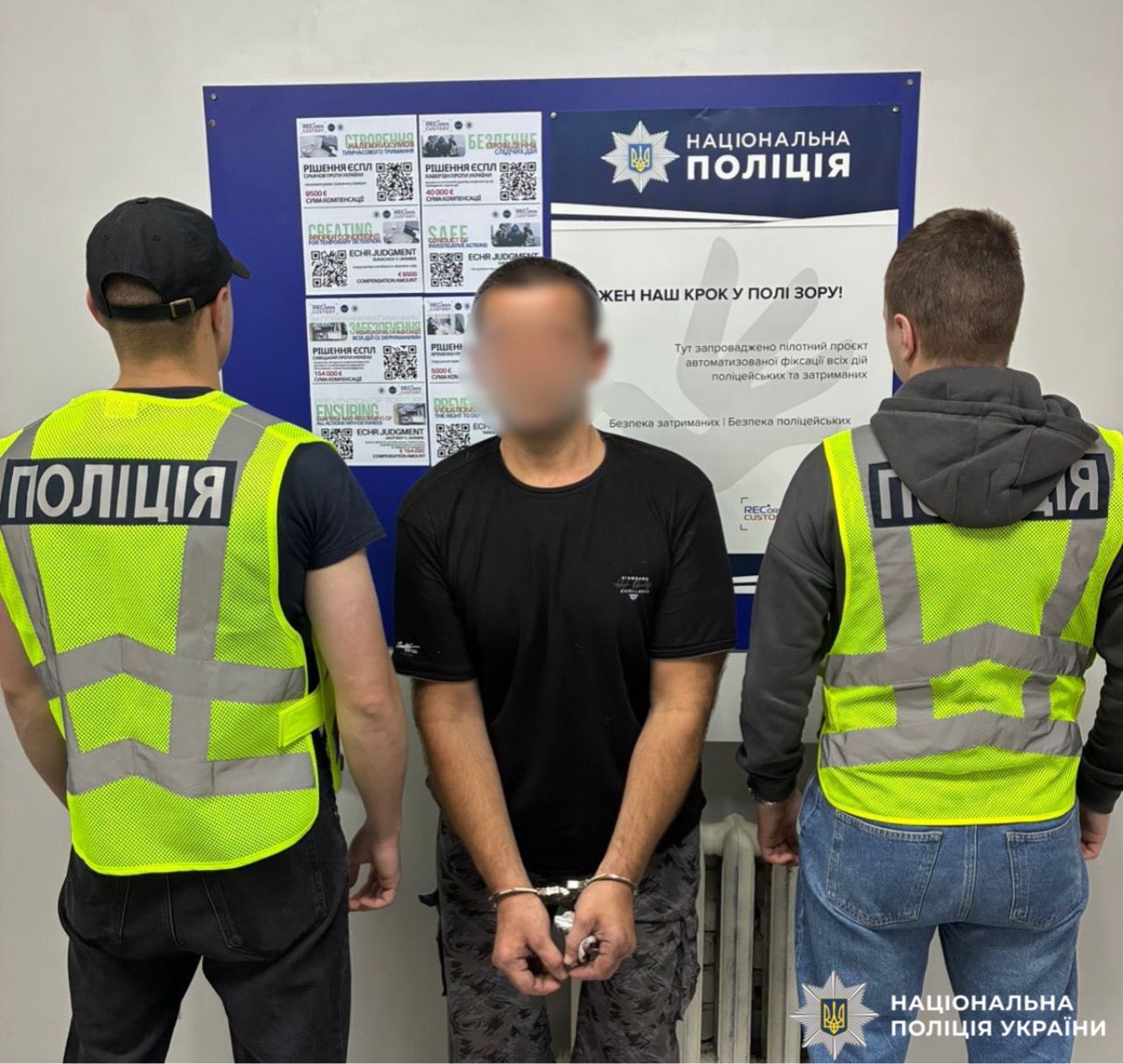 На фото затримана особа та працівники поліції.