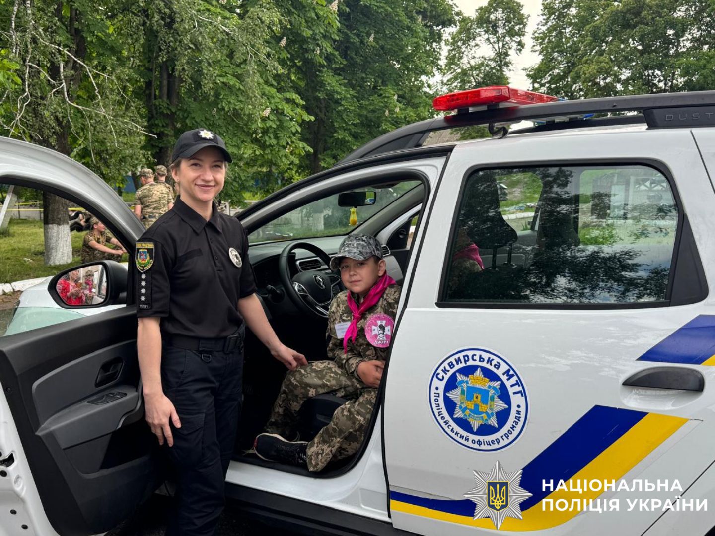 На фото зображені діти та поліцейська