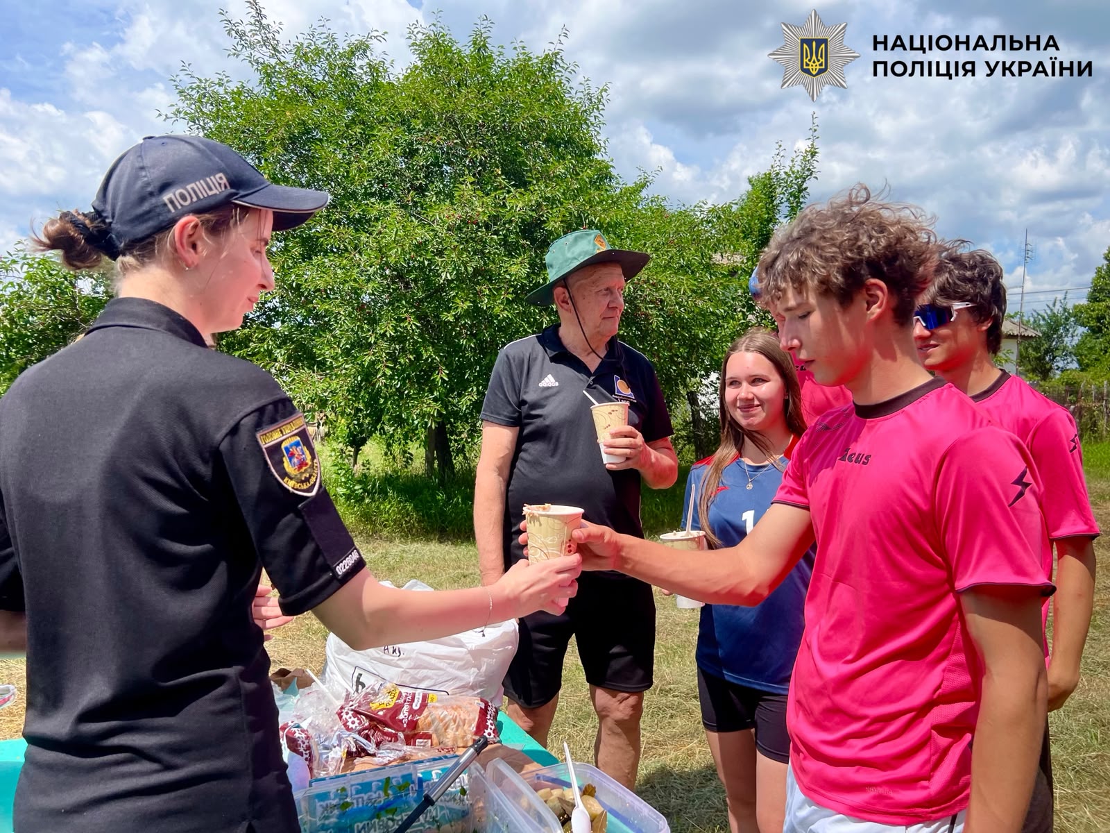 На фотографії зображено поліцейських Київщини, які долучилися до спортивного фестивалю та пригостили учасників поліцейською польовою кашею.