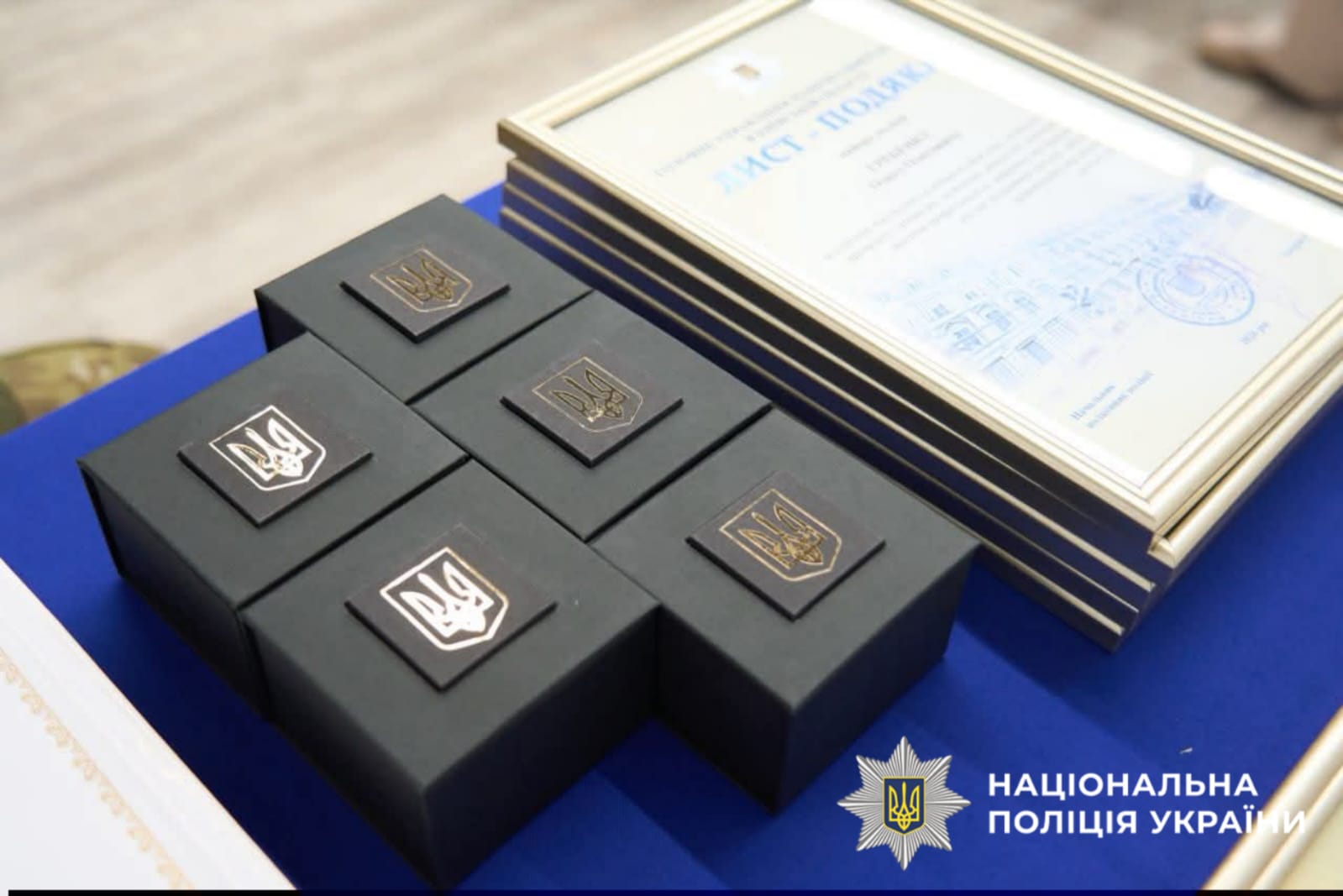 На фотографії зображено відзнаки та цінні подарунки, які вручено кращим поліцейським столичного регіону з нагоди Дня Конституції України.