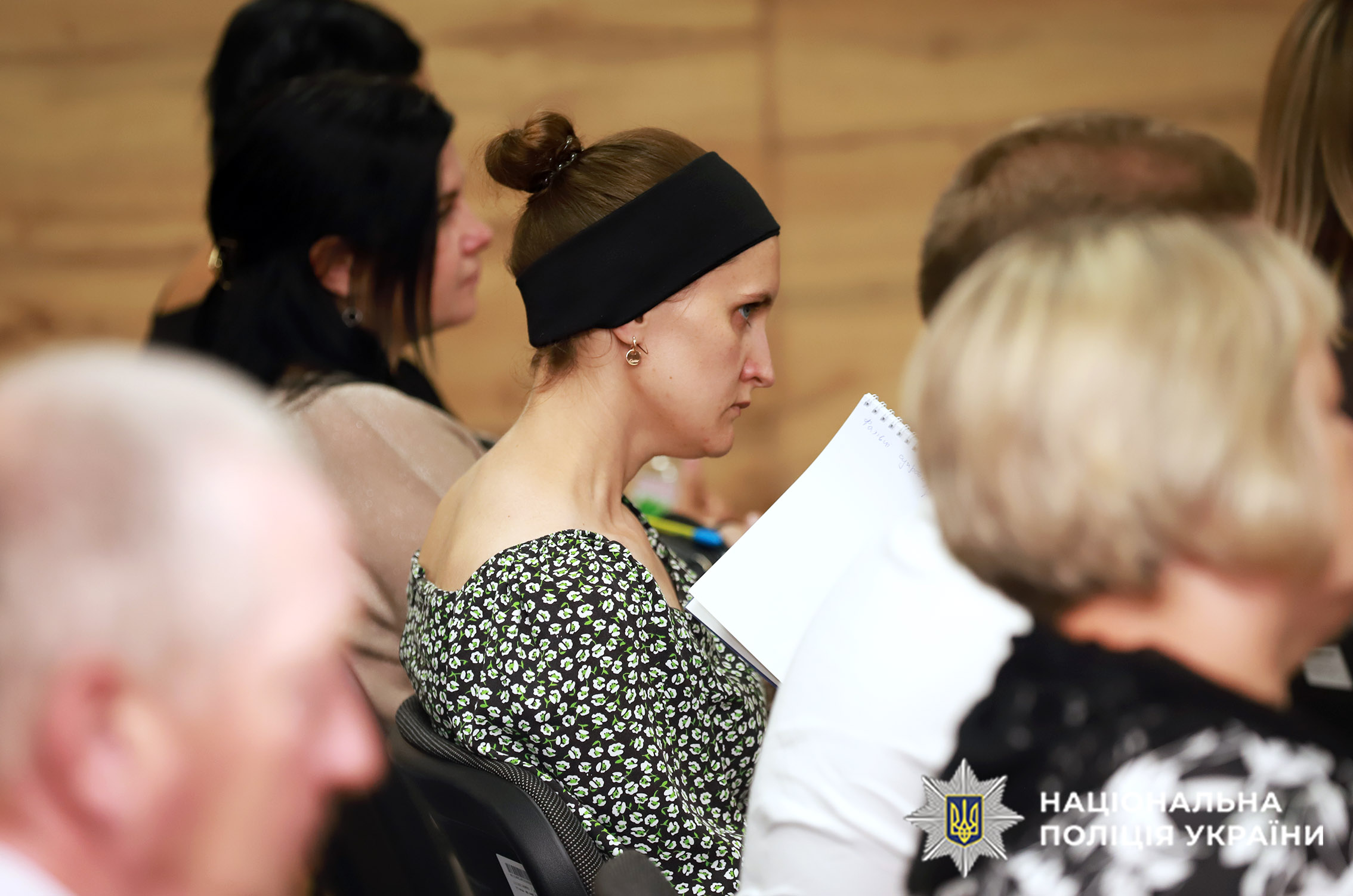 Дружина загиблого поліцейського з чорною траурною пов’язкою на голові
