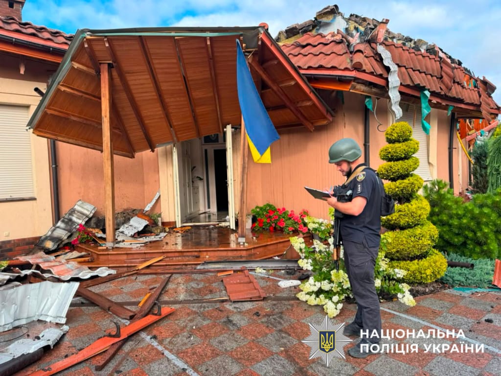 На фотографії зображено поліцейського, який документує наслідки атаки на столичний регіон.