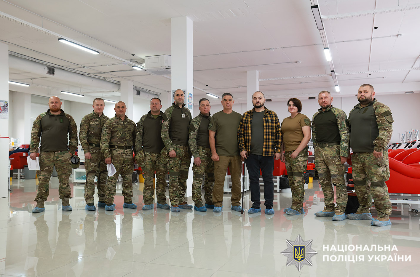 На фото стоять в один ряд 11 бійців спецпідрозділів поліції Хмельниччини у формі колтору хакі. Серед них одна жінка.