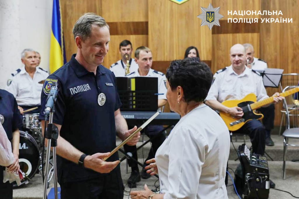 На фото перший заступник керівника ГУНП в Київській області вручає Подяку меличній працівниці.