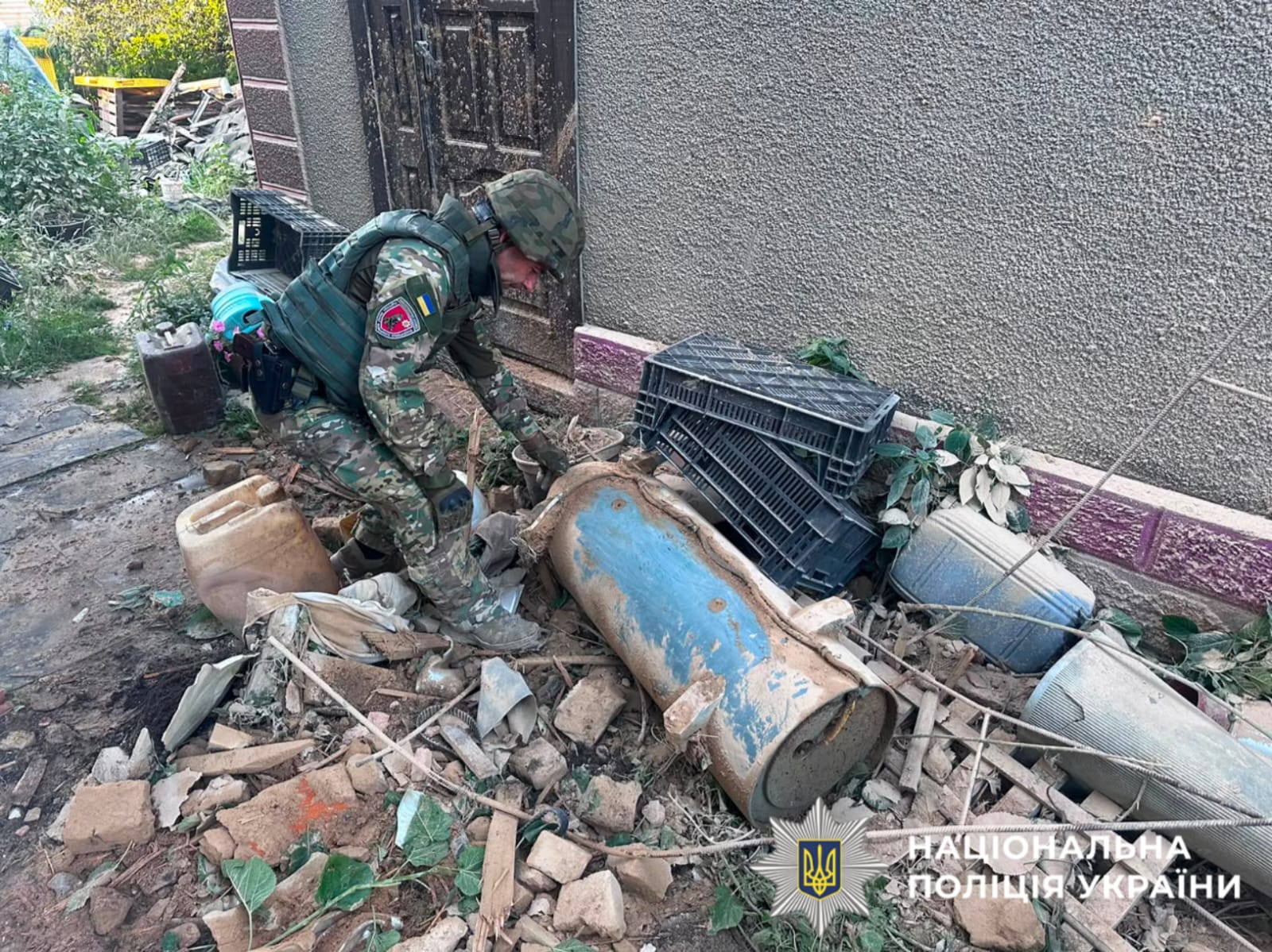 На фотографії зображено поліцеського, який фіксує наслідки атаки ворога на Київщині.