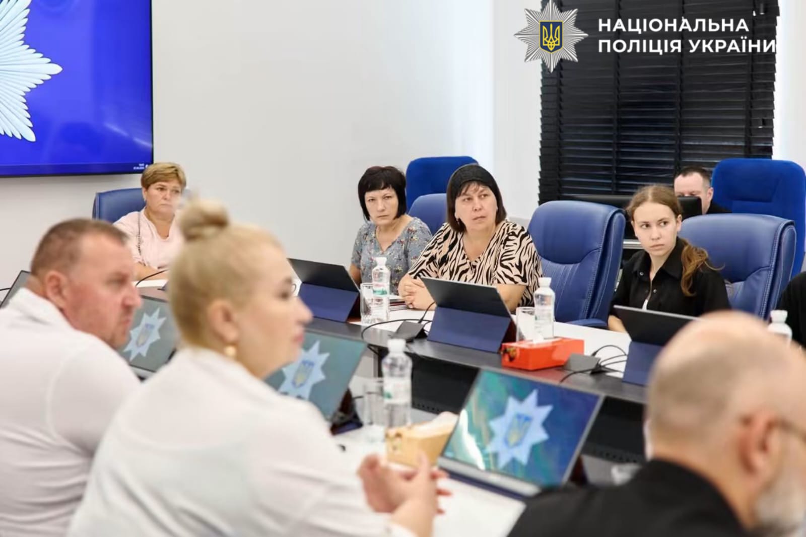 На фотографії зображено зустріч поліції Київщини із представниками родин поліцейських-захисників, які зникли безвісти.