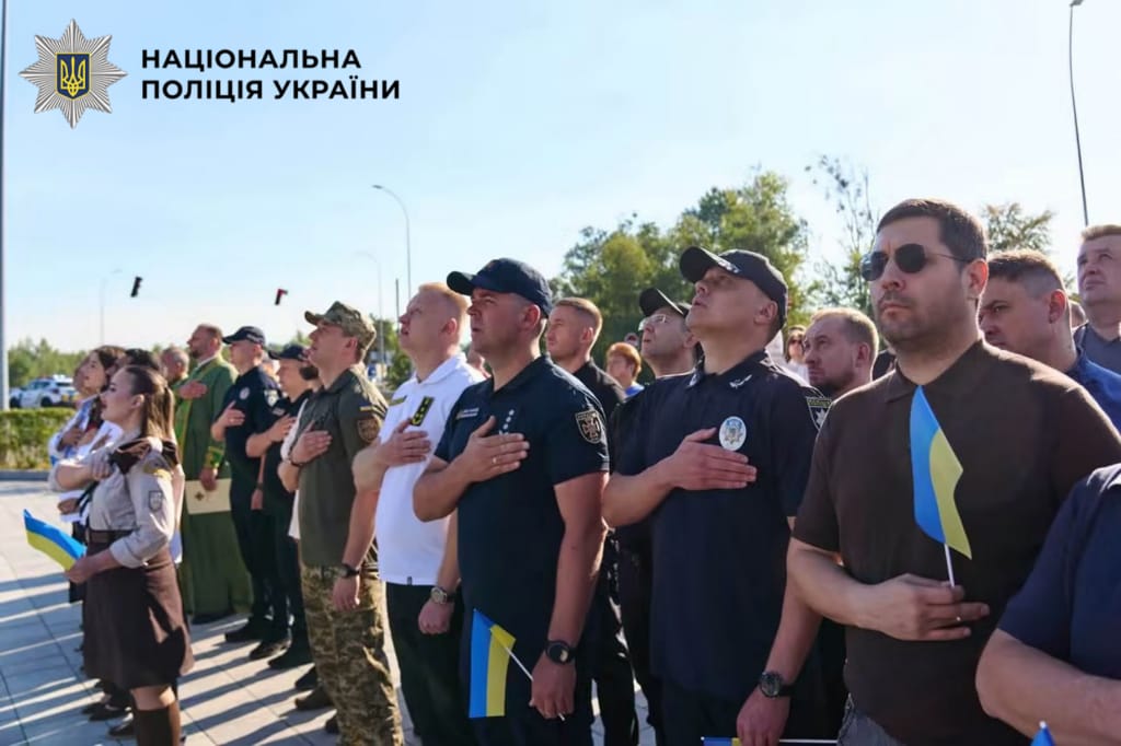 На фотографії зображено поліцейські Київщини, які спільно з громадою взяли участь у піднятті синьо-жовтого стягу на перехресті Бучі та Ворзеля.
