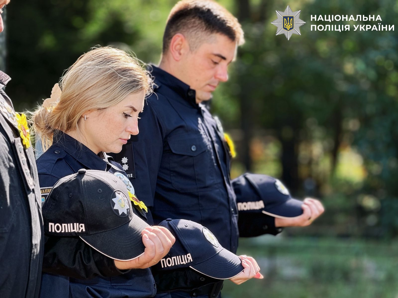 На фото поліцейські під час хвилини мовчання біля місця поховання колег.