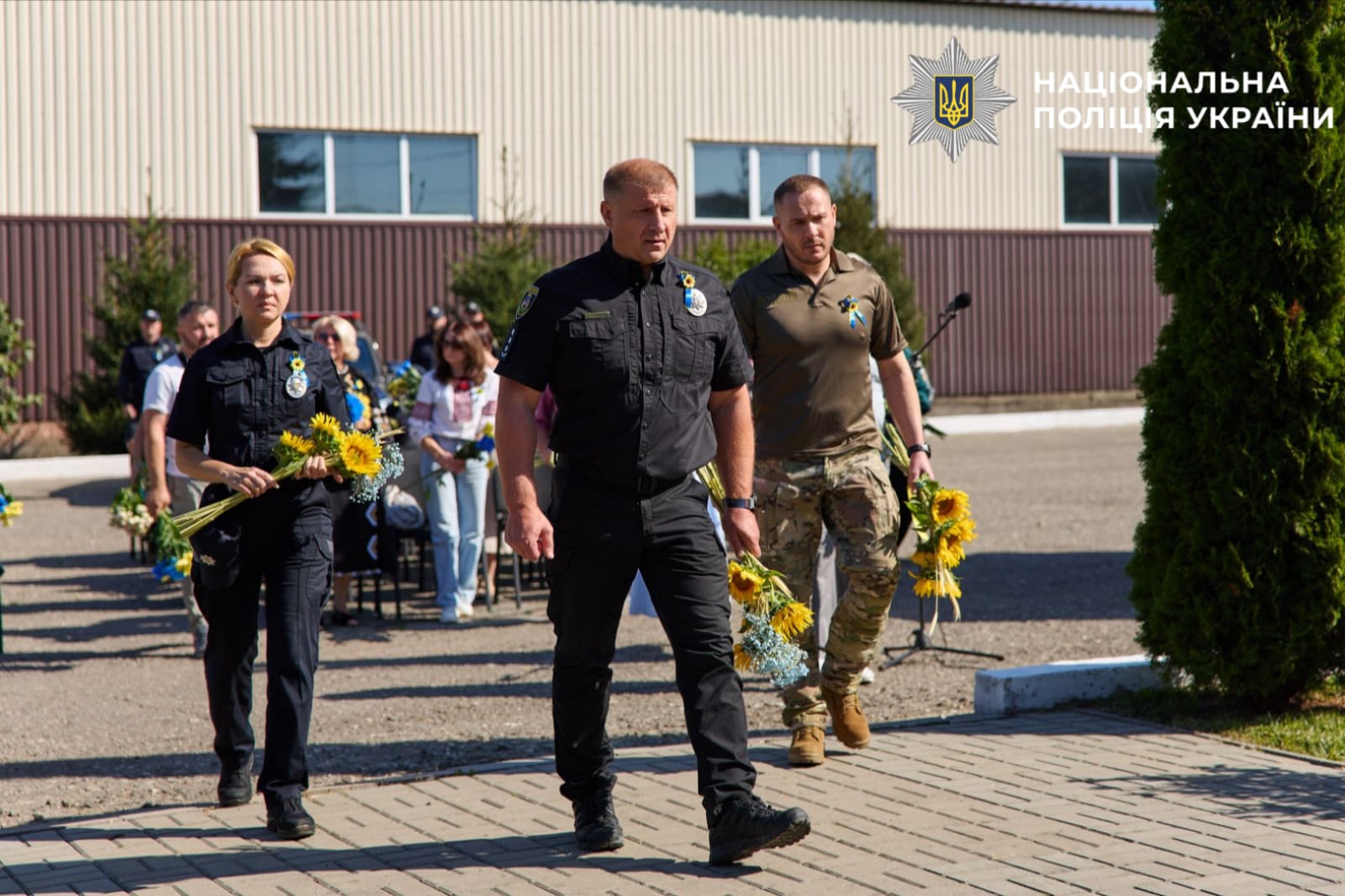 На фото правоохронці ідуть до мемореалу пам'яті щоб покласти квіти до нього.