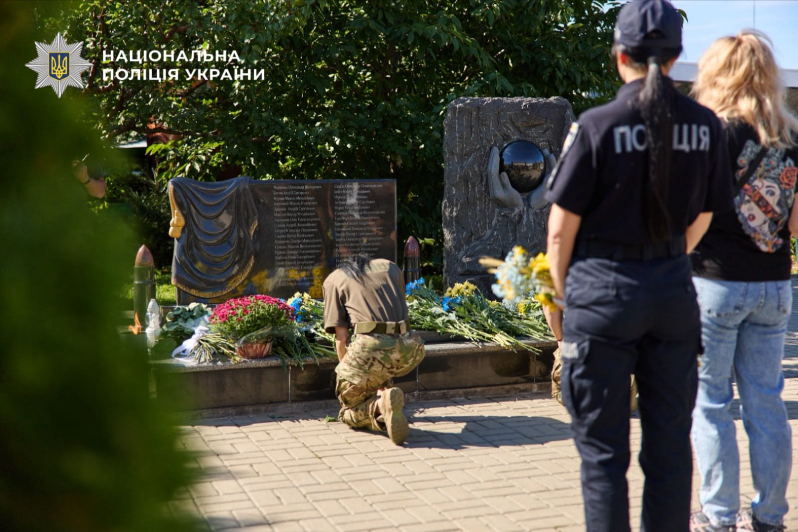 Спецпризначенка покладає  квіти до мемореалу пам'яті загиблих колег