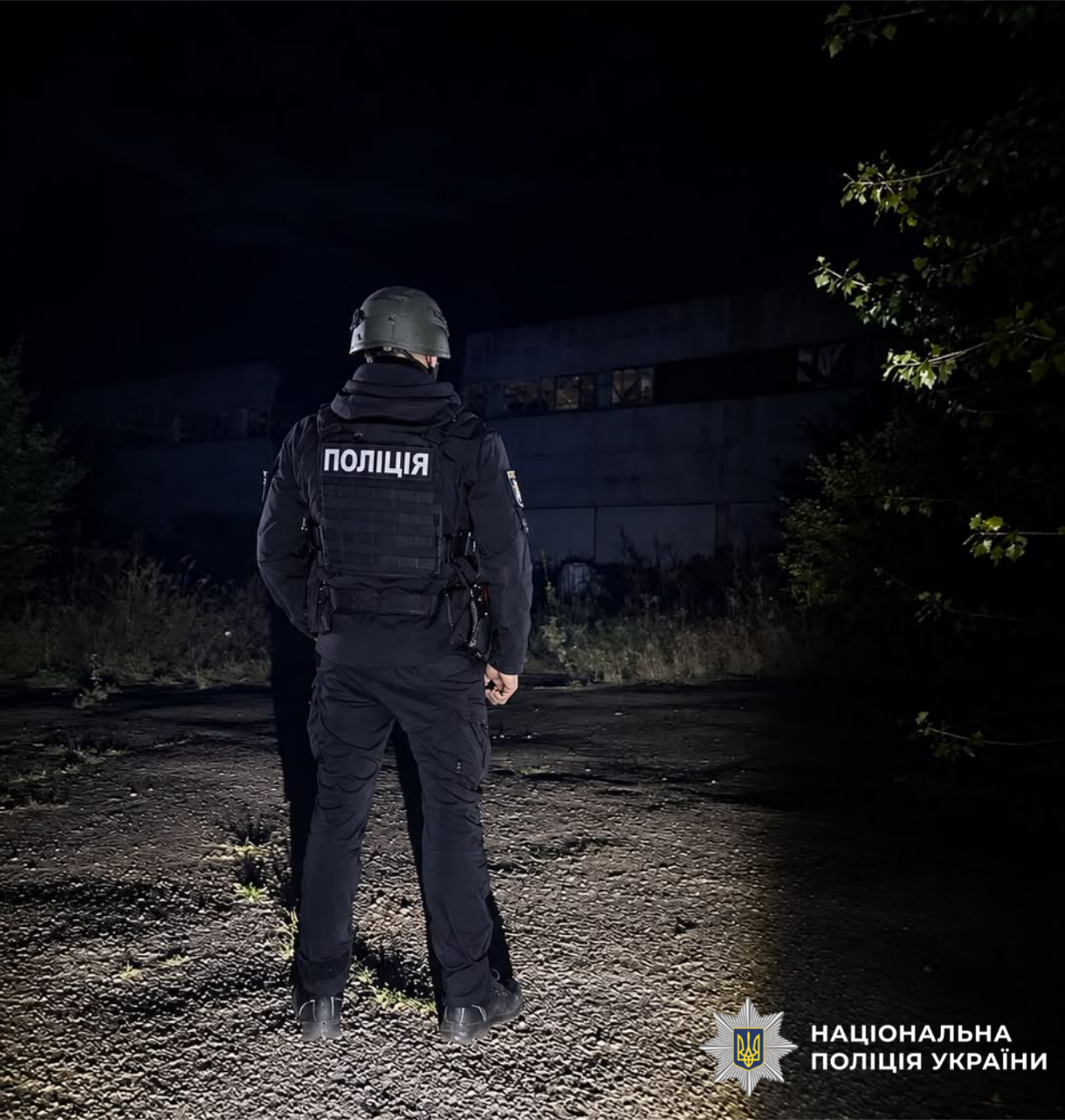 На фотографії зображено поліцейського Київщини, який документує наслідки ворожої атаки столичного регіону.