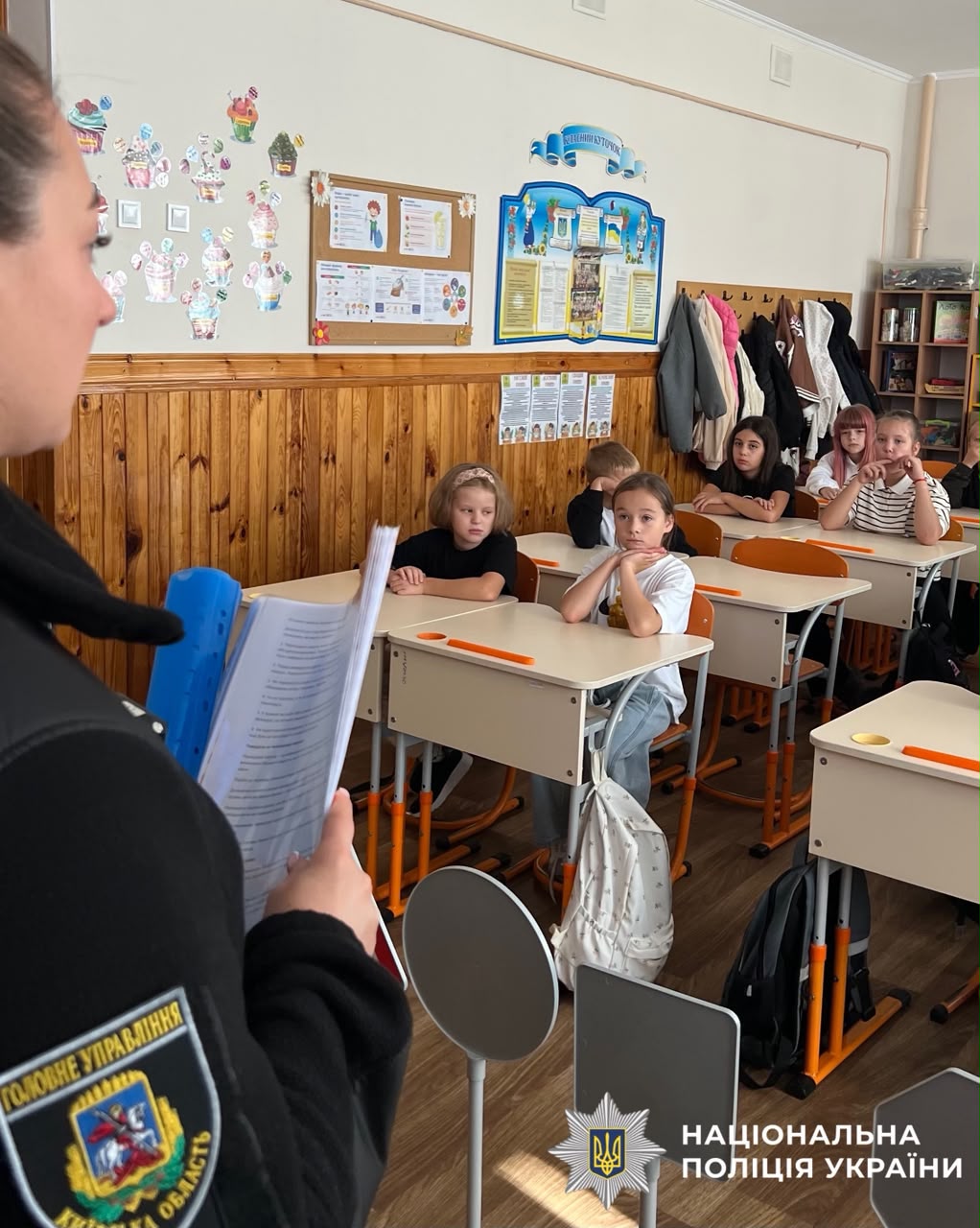 На фото поліцейська, яка проодить заняття та присутні діти.