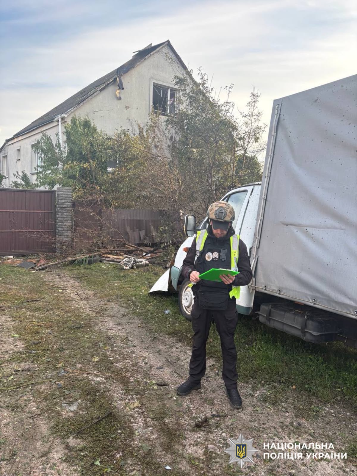 На фотографії зображено поліцейського Київщини, який документує наслідки ворожої атаки.