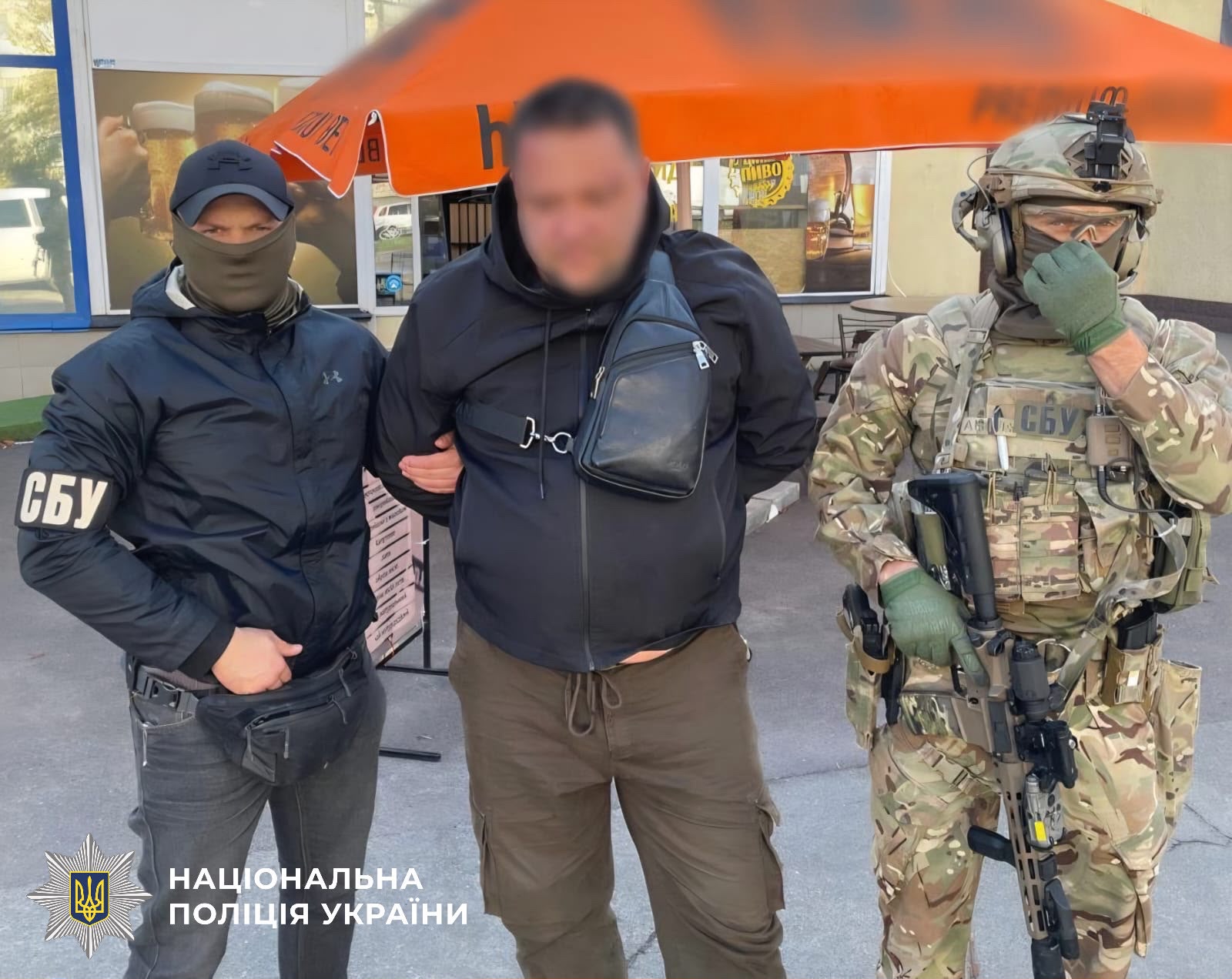 На фото один з фігурантів та правоохоронці.