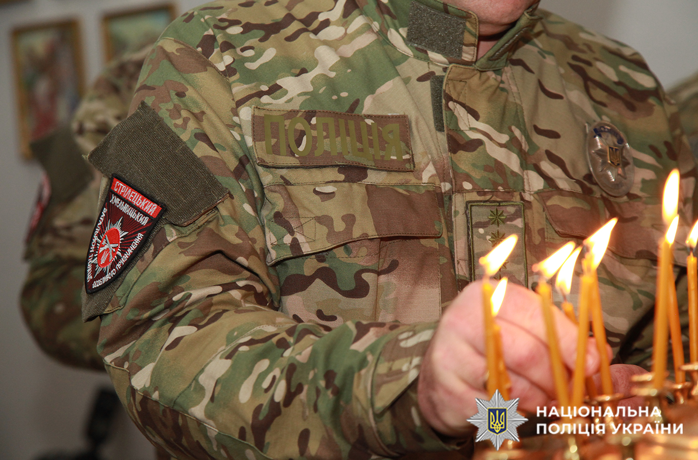 Боєць стрілецького ставить свічку