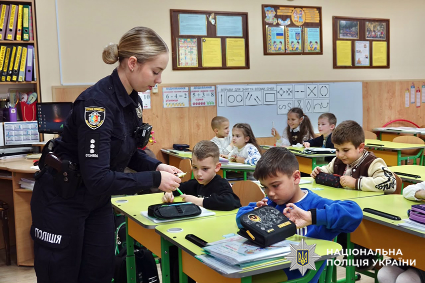 Поліцейські роздає дітям інформаційні матеріали