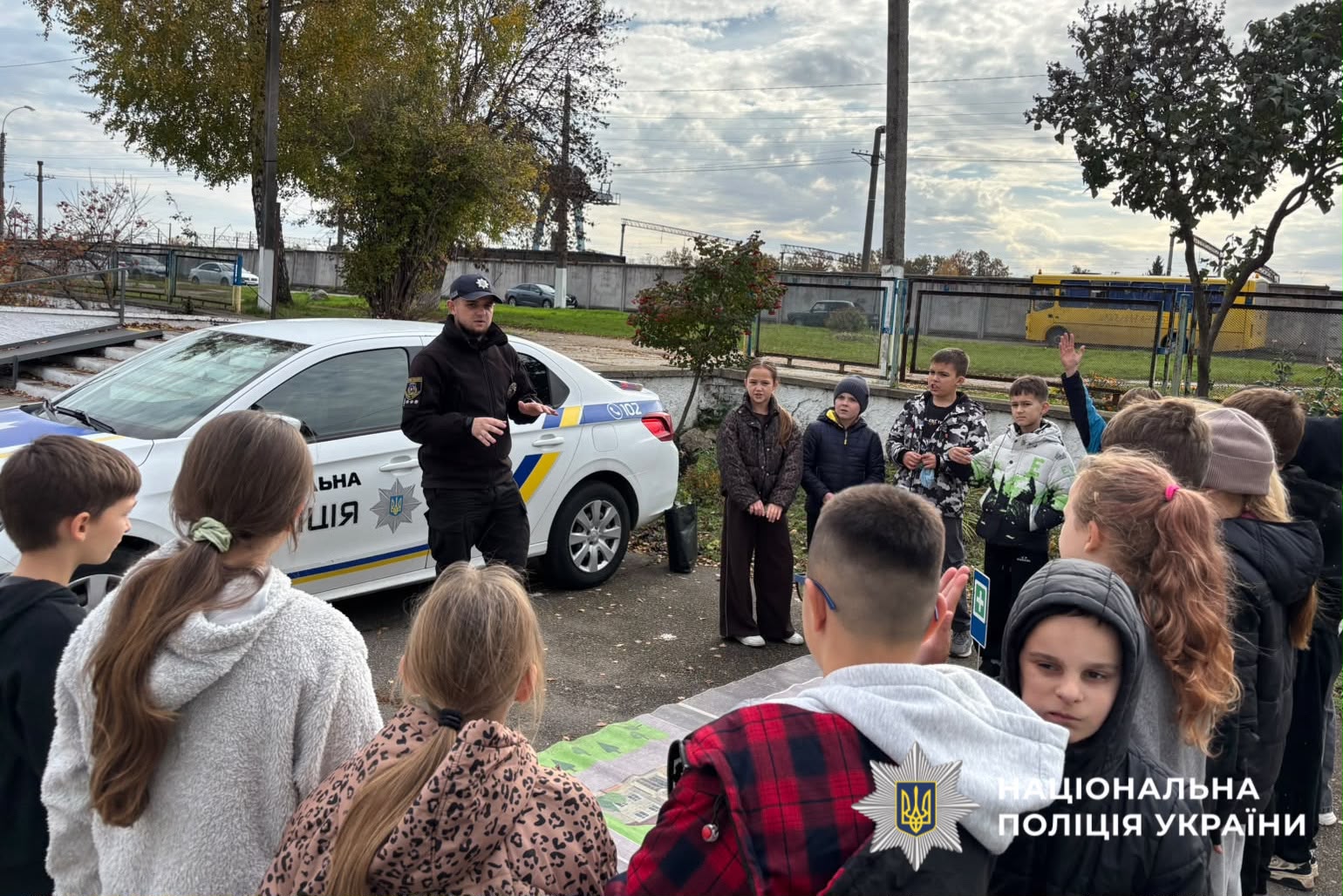 На фото зображені діти та поліцейський