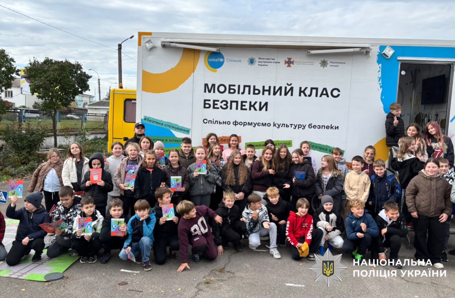 На фото зображені діти та поліцейський