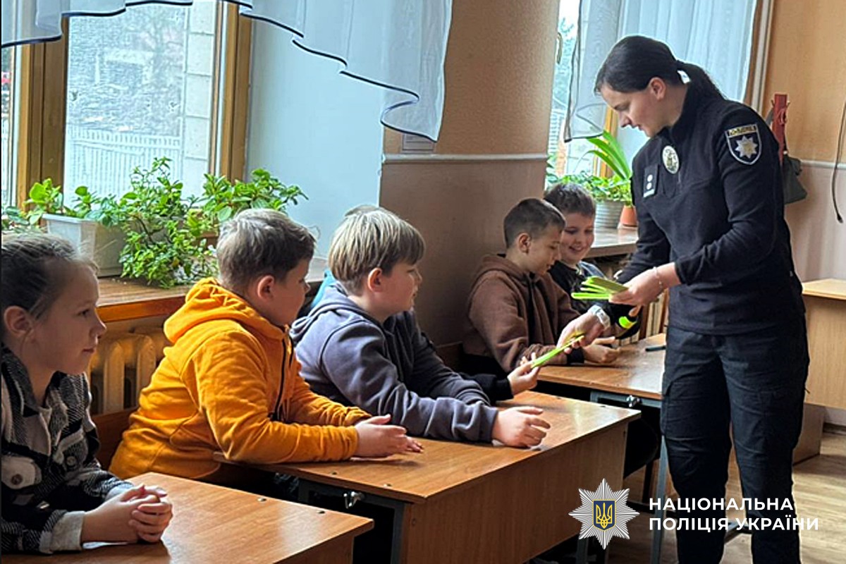 поліцейська роздає дітям світловідбивні елементи