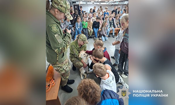кінолог та собака показують дітям курс дресури
