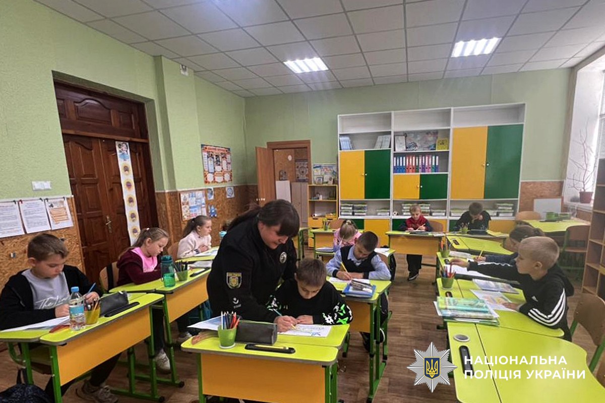 Інспекторка допомогає дітям малювати малюнок захисникам