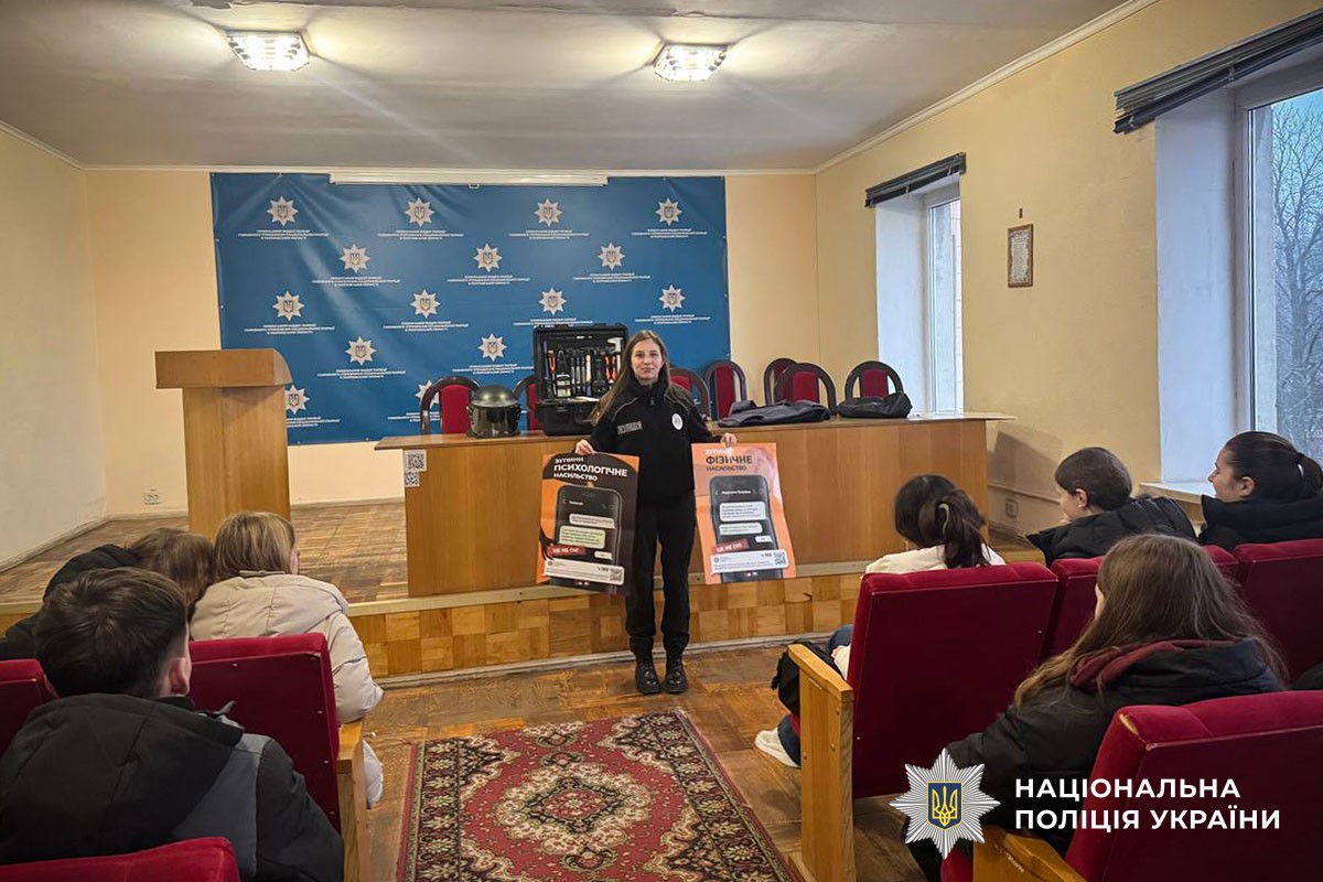 Поліцейська демонструє профілактьчні плакати