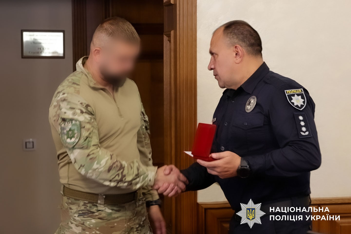 Євген Нестеренко вручає нагороду поліцейському