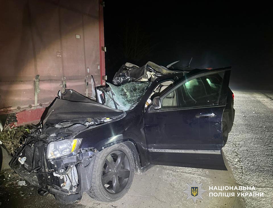 Понівечений позашляховик під напівпричепом вантажівки