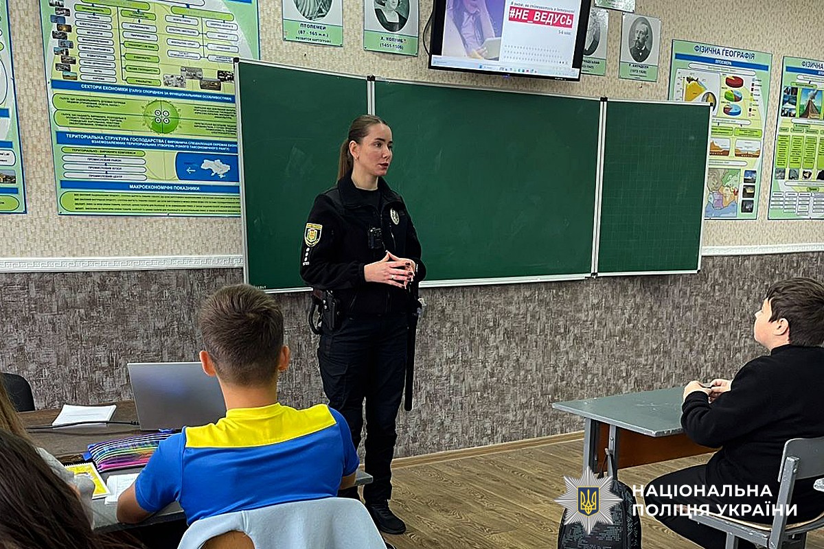 Поліцейська говорить з дітьми на тему безпеки