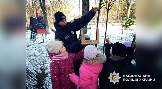 Поліцейські та діти підгодовують птахів узимку