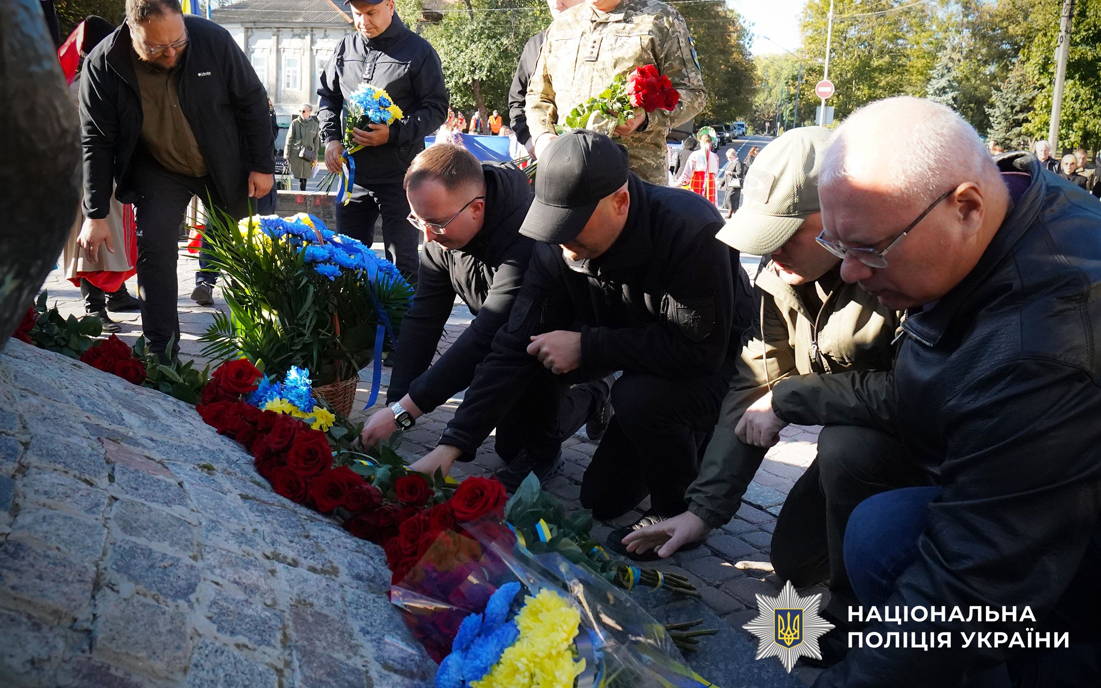 Учасники кладуть квіти до підніжжя