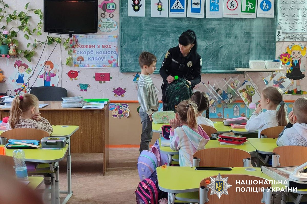 Поліцейська розповідає дітям про світловідбивачі 