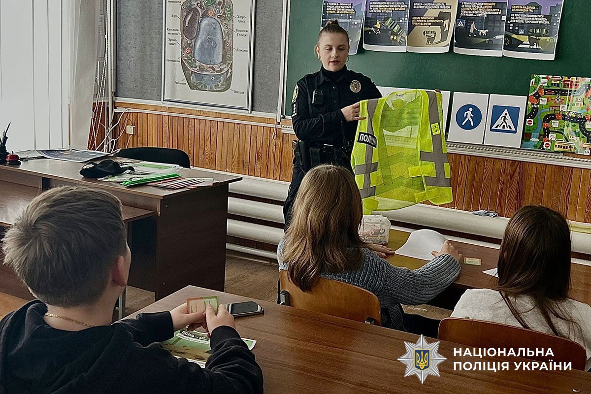 Поліцейська розповідає дітям про світловідбивачі 