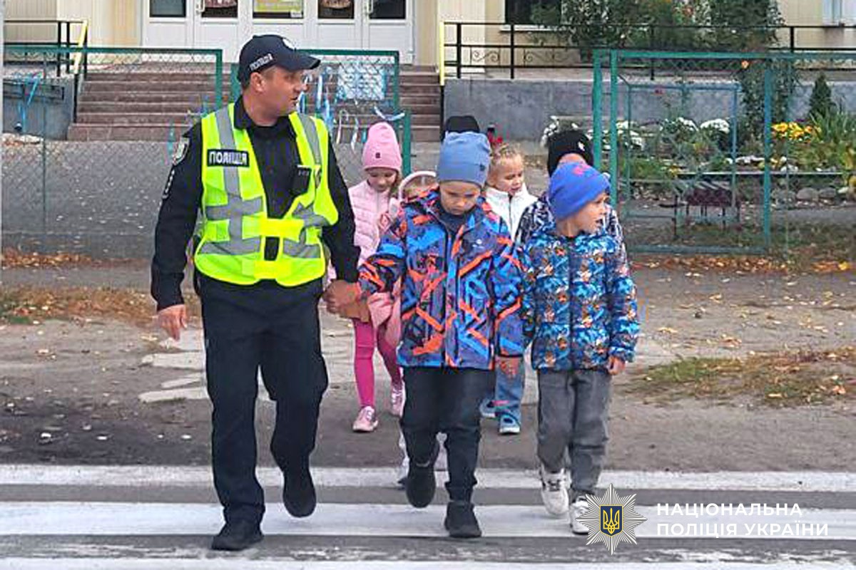 поліцейський переводить дітей через дорогу 