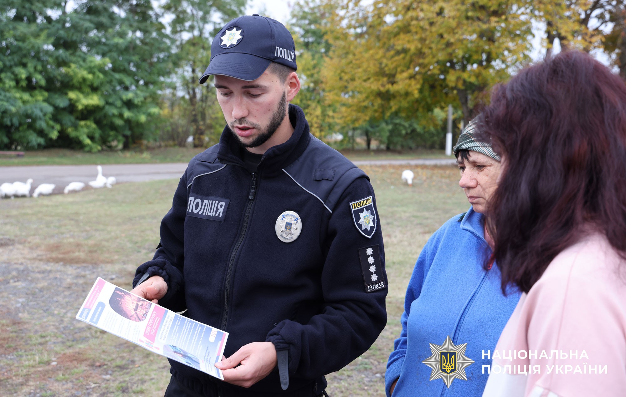 Поліцейський офіцер громади розяснює місцевій мешканці про наслідки спалення сухої трави