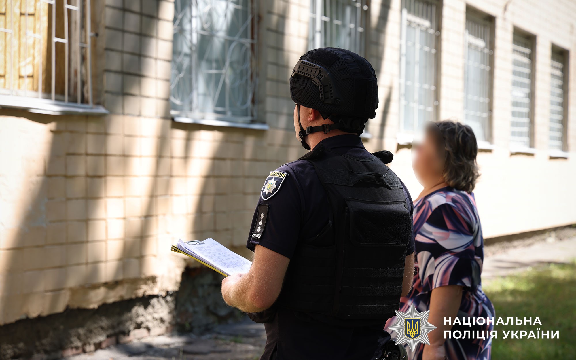 Поліцейський документує наслідки атаки, поруч стоїть жінка