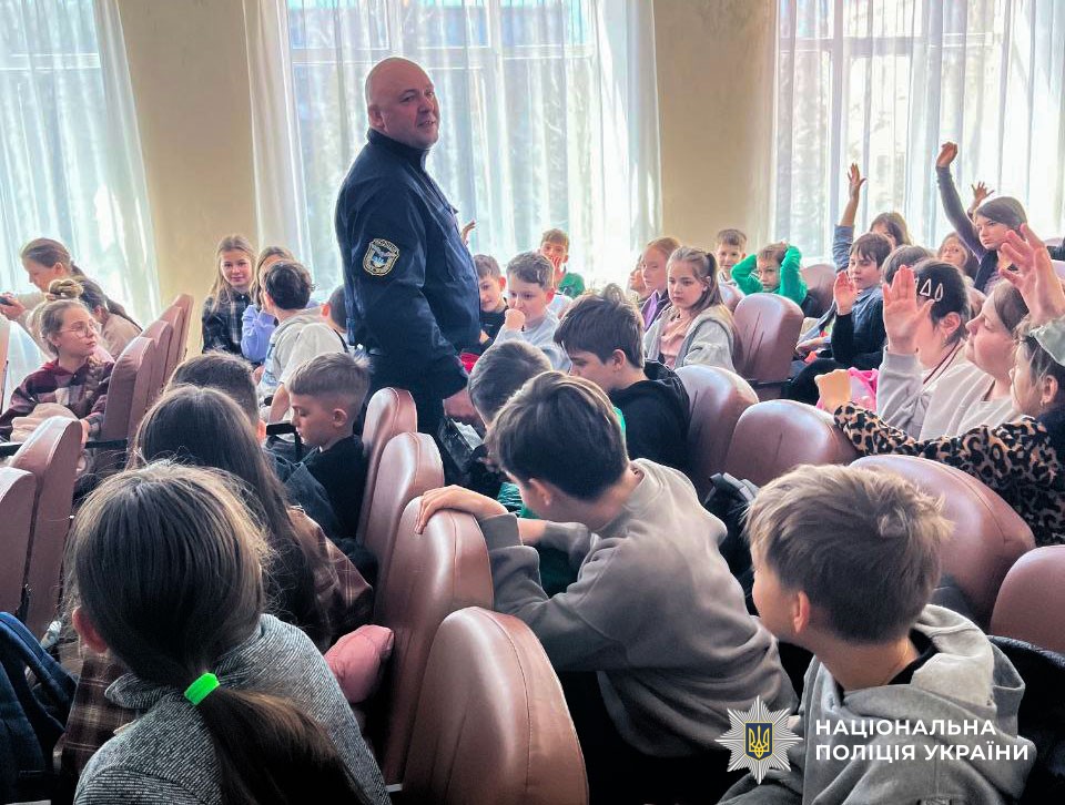 Поліцейський поруч з дітьми відповідає на їхні питання