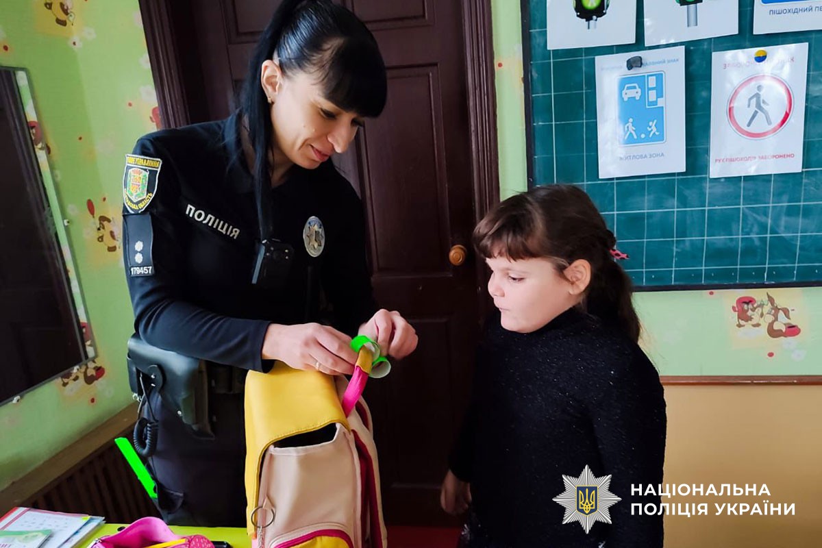 Поліцейська розповідає дітям про світловідбивачі 