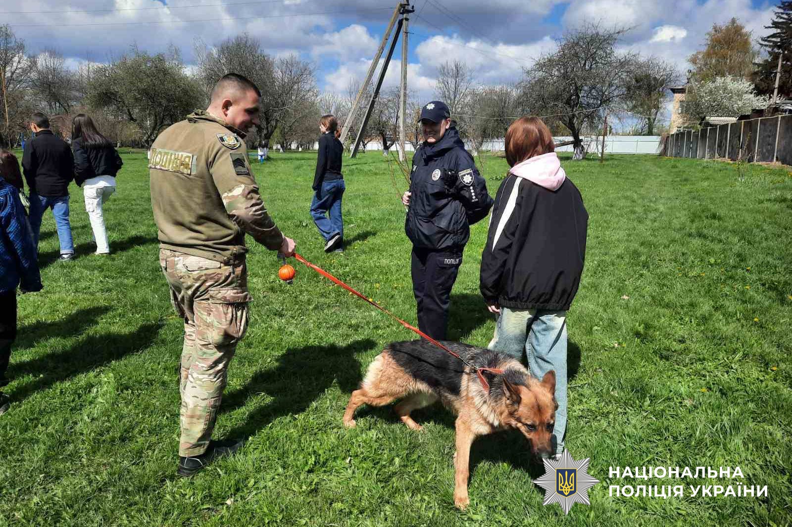 Діти дивляться на виступ службових собак