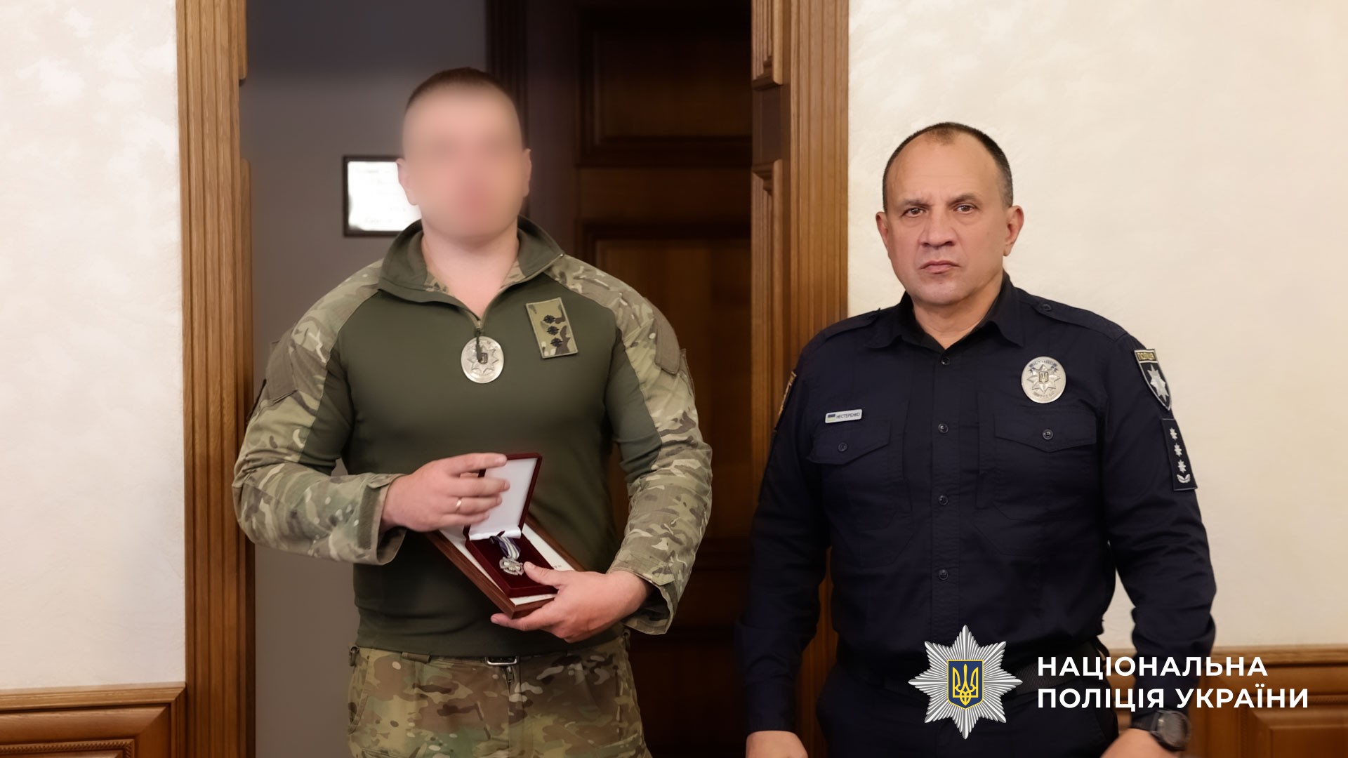 Євген Нестеренко вручає нагороду поліцейському