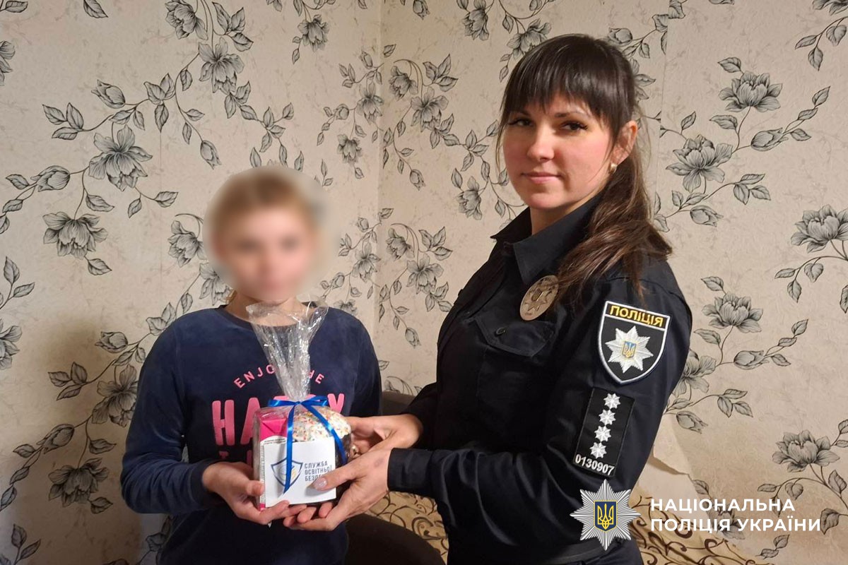 Поліцейська вручає дитині пасочку