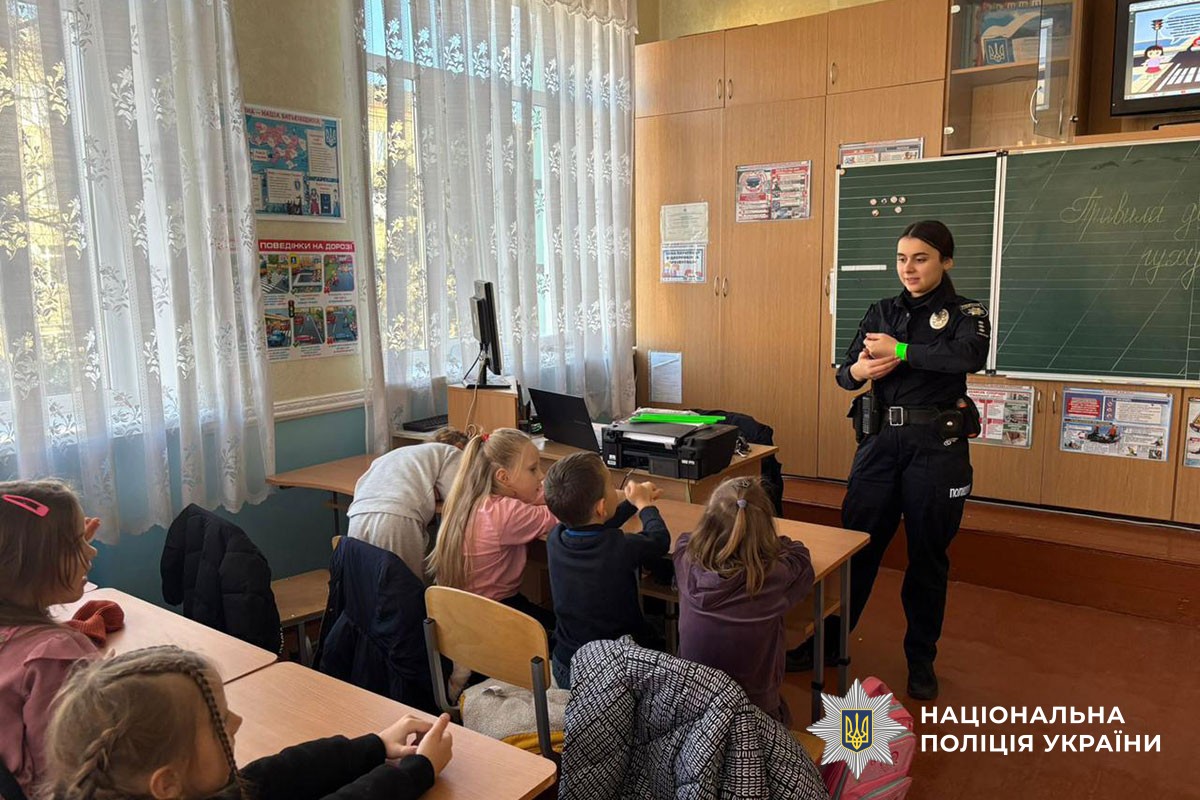 Поліцейська розповідає дітям про світловідбивачі 