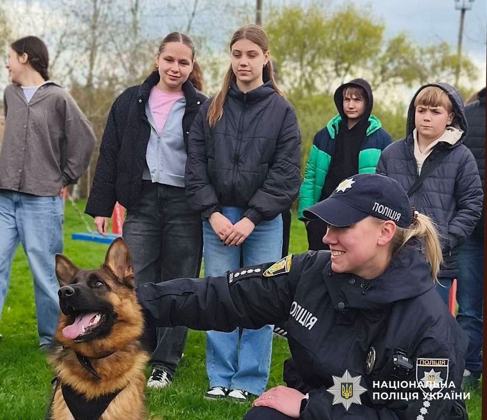 Діти дивляться на виступ службових собак