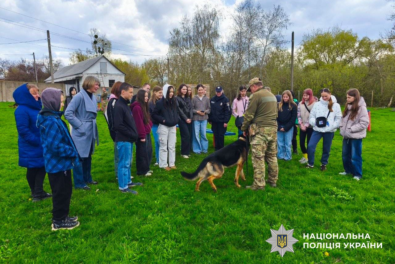 Діти дивляться на виступ службових собак