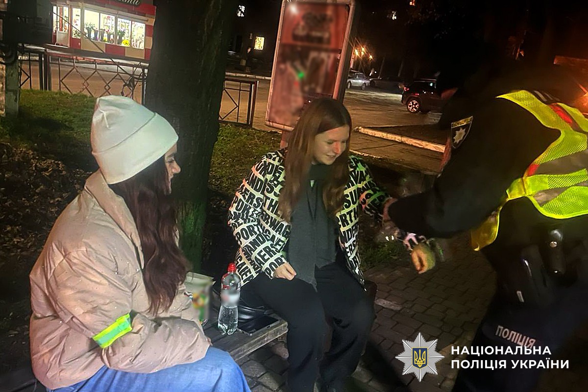 Поліцейський розповсюджує свтловідбивні елементи серед молоді