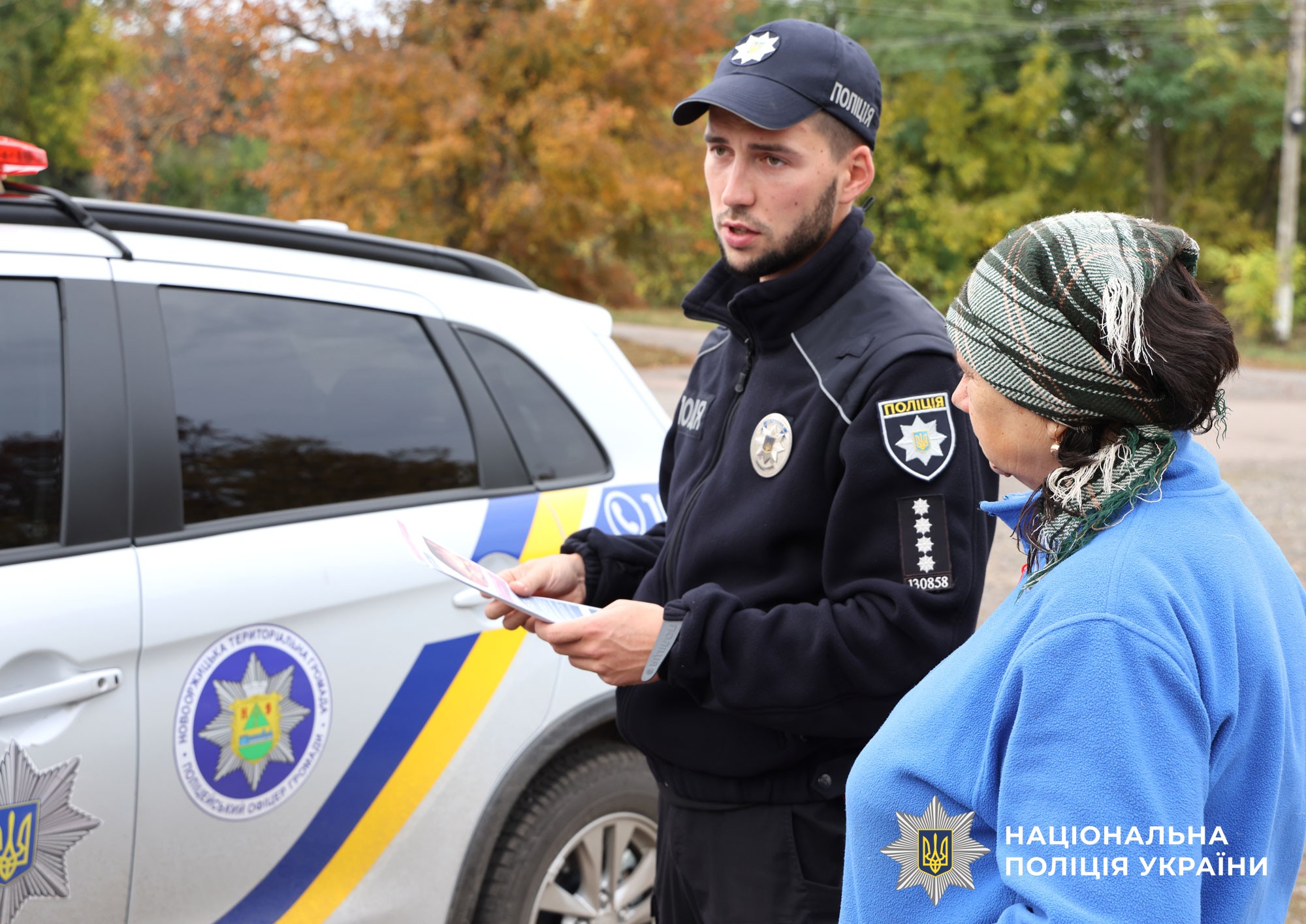 Поліцейський офіцер громади розяснює місцевій мешканці про наслідки спалення сухої трави