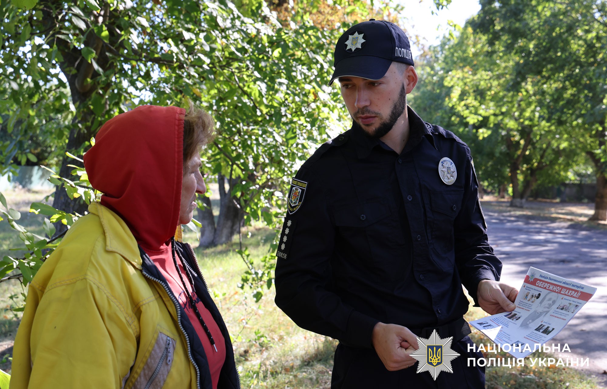 Поліцейський спілкується з жителями громади щодо шахрайств та радить як їх уникнути