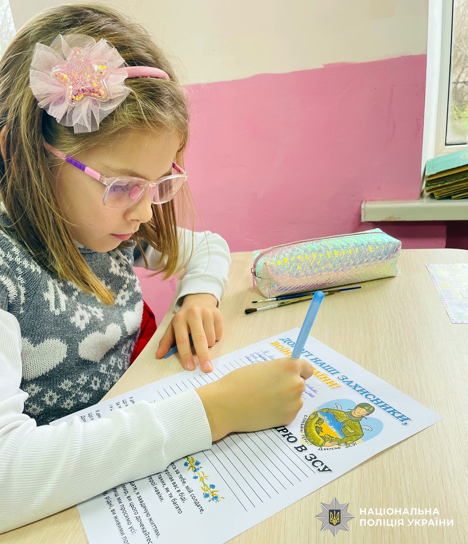 дівчинка пише листа військовим