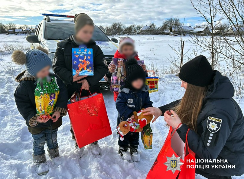 Поліцейська дарує дітям подарунки 