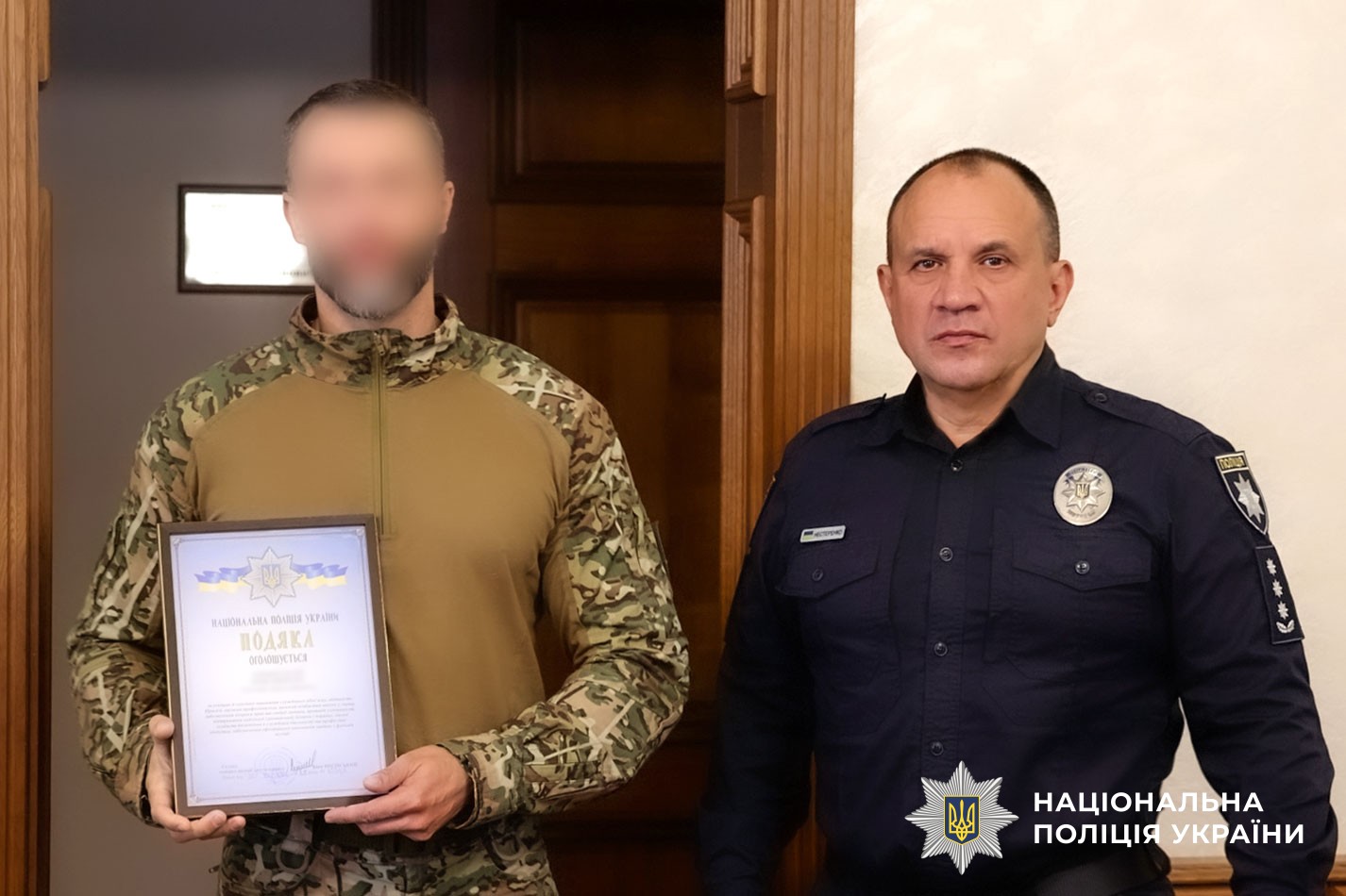 Євген Нестеренко вручає нагороду поліцейському 